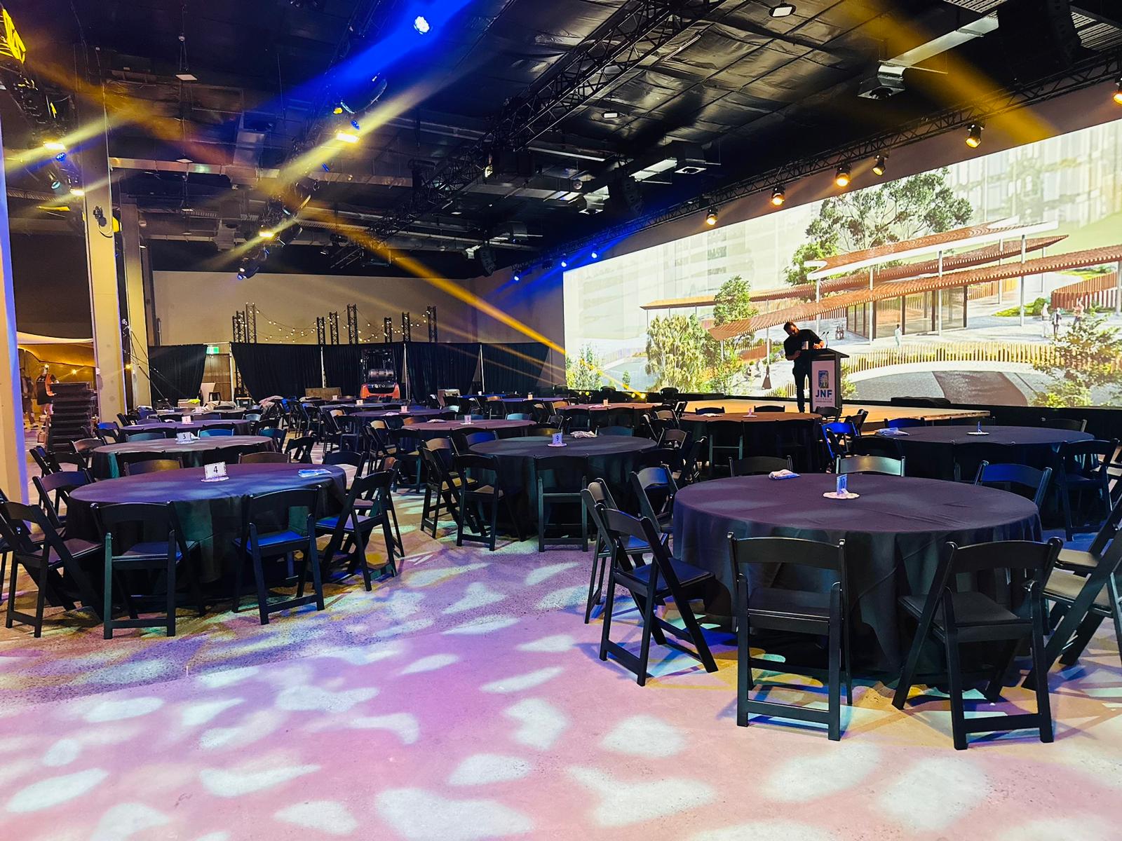 black padded chairs with round banquet tables