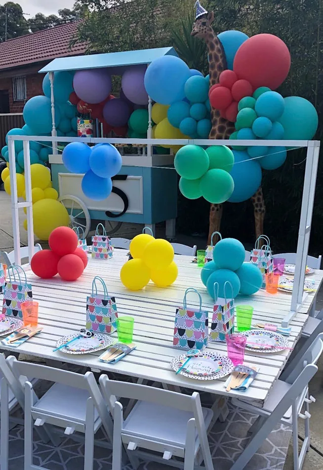 kids party decorated with balloons and white chairs