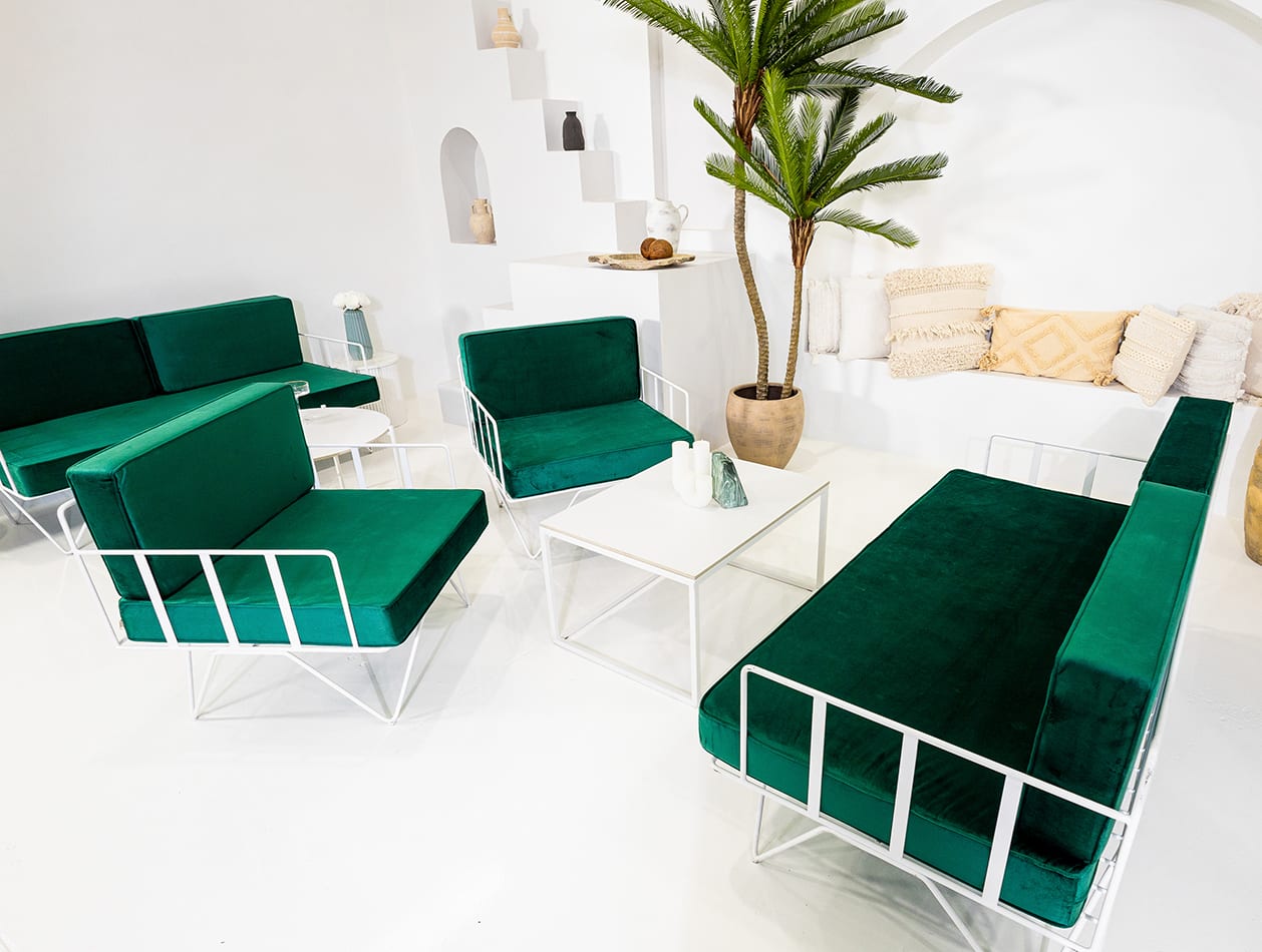 a-white-wire-armchair lounge with green velvet cushions