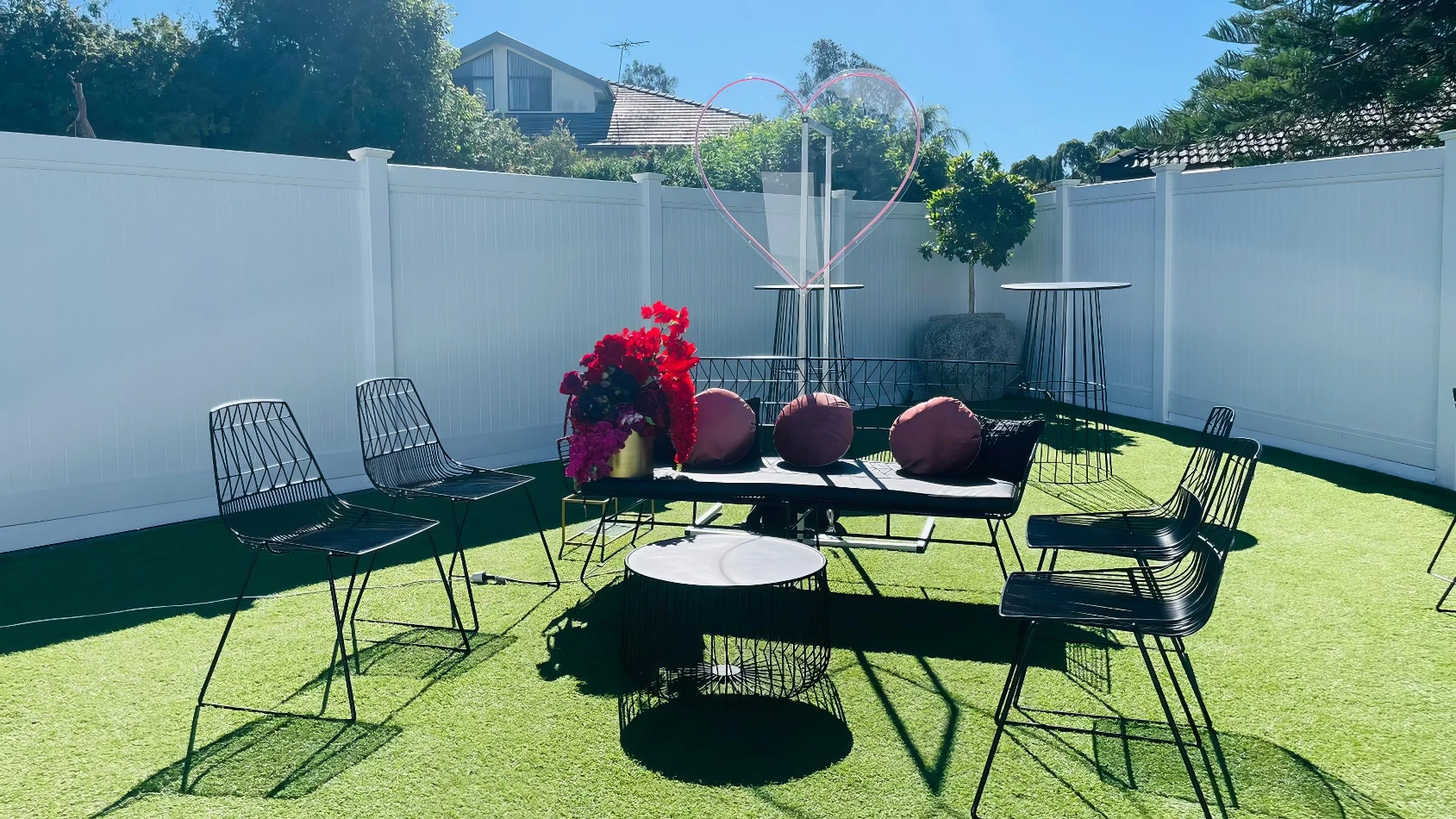 outdoor lounge setting with black wire chairs and black wire arrow lounge