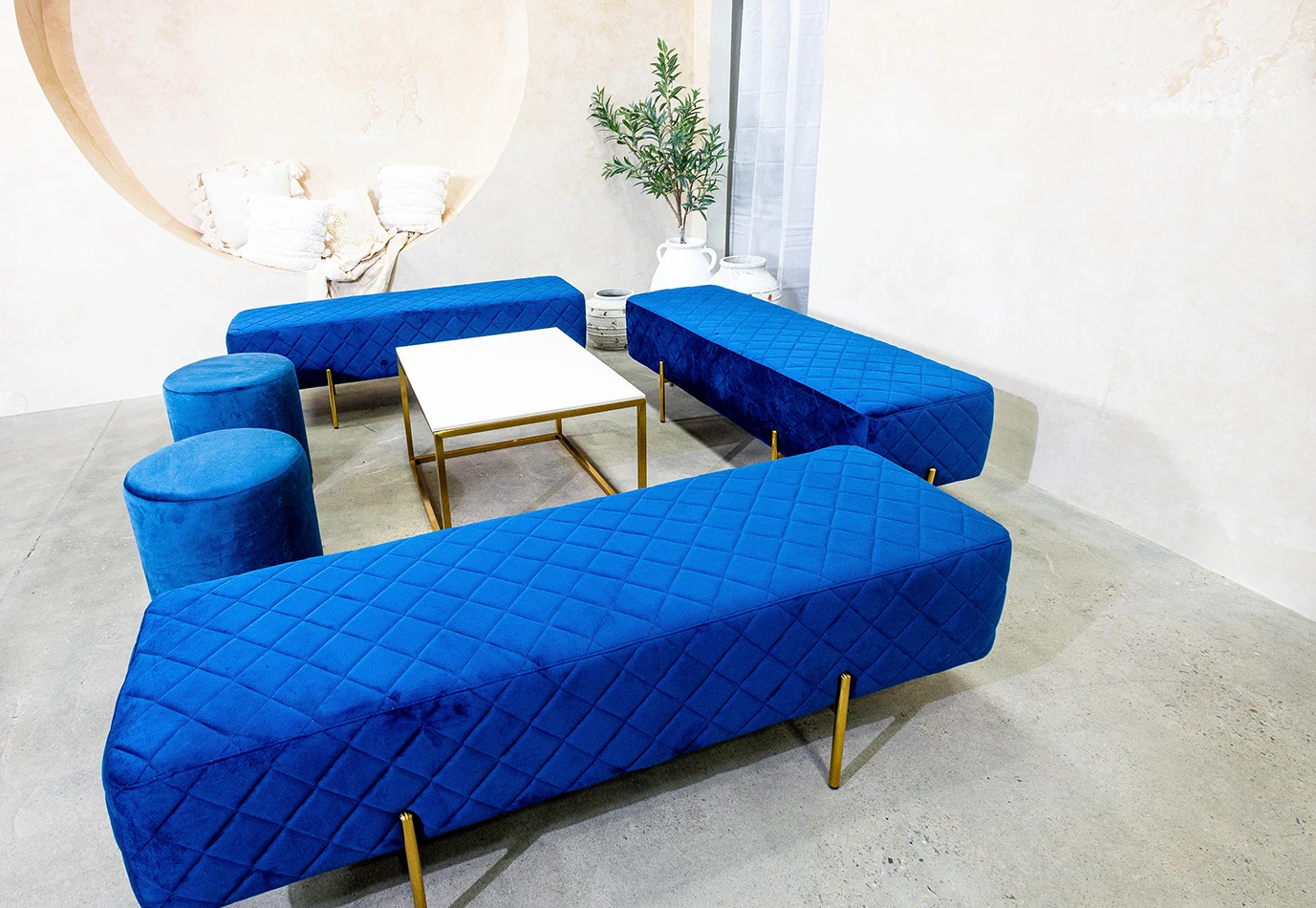 a lounge setting with navy blue ottoman benches and stools