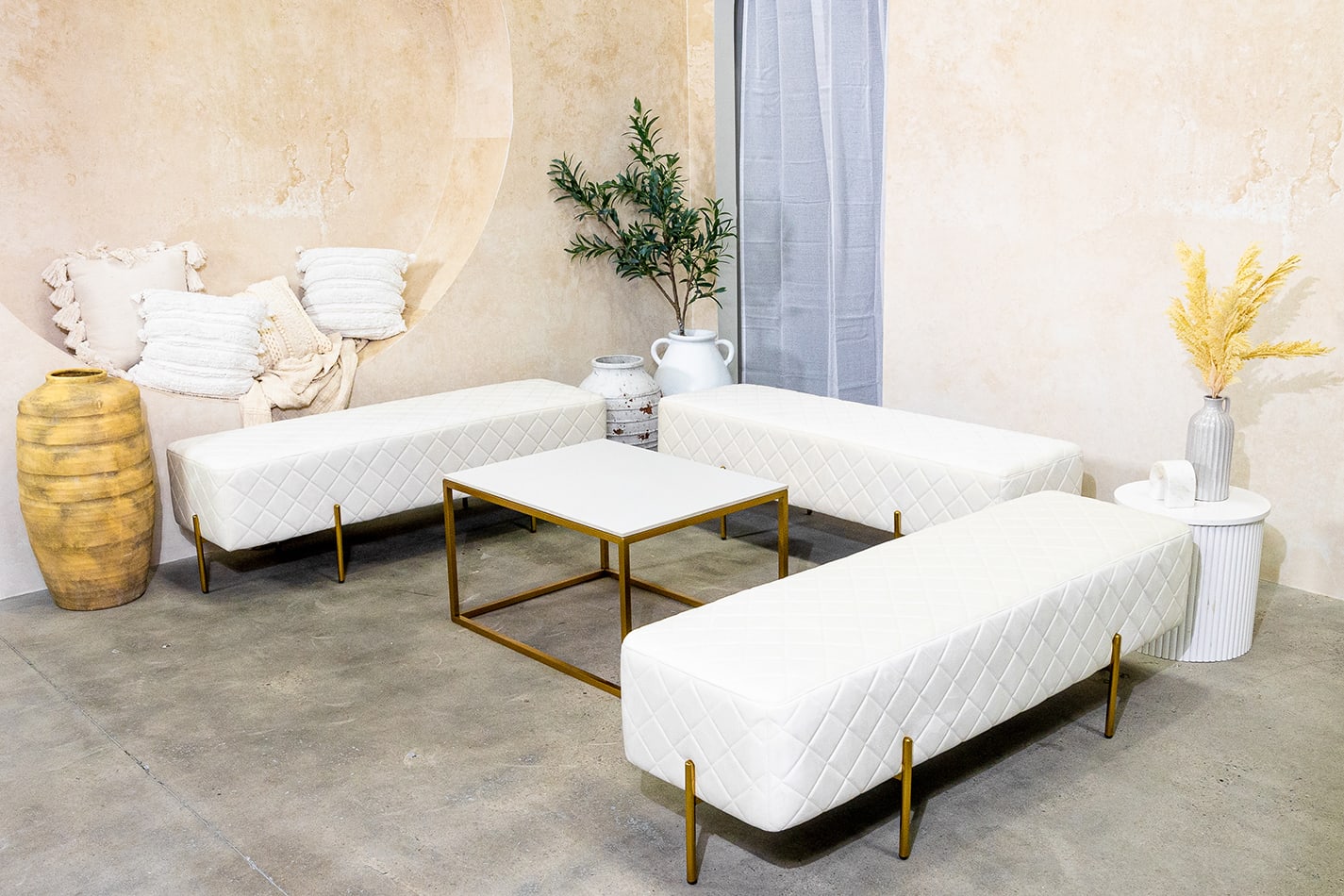 lounge setup with white velvet ottoman benches and a coffee table